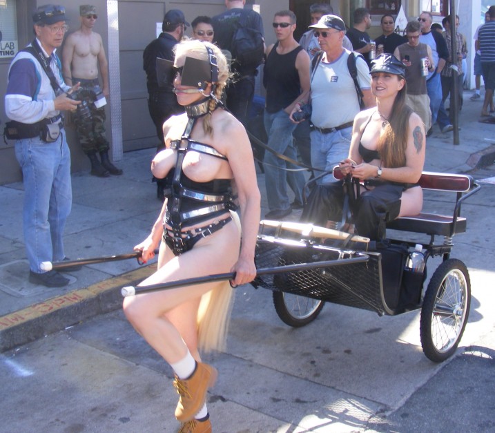 Nude pony girl pulling her mistress in a cart in public